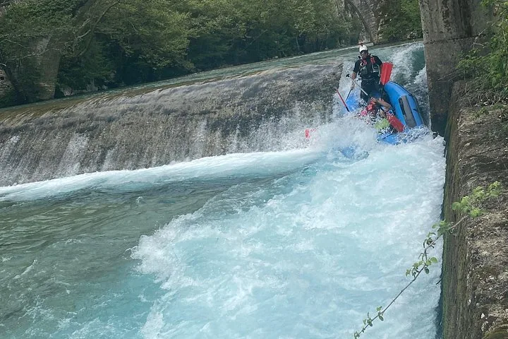 Rafting su una rapida vicino a un ponte in pietra nel Voidomatis.