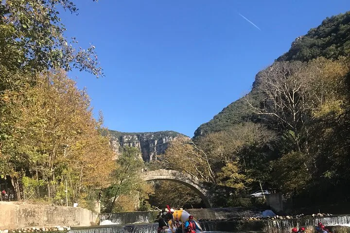Un gruppo che fa rafting sotto un vecchio ponte in pietra sul Voidomatis.